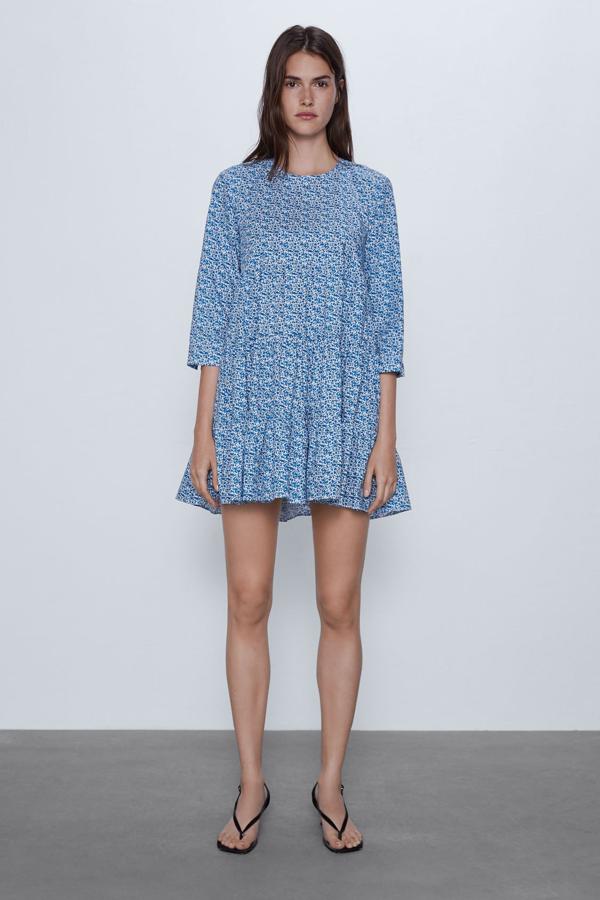 Otra de las propuestas mini de Zara es este vestido corto de cuello redondo y manga por debajo del codo en tonos azules y blancos. Tiene el bajo acabado en volante y de 29,95 euros ha pasado a 15,99 euros.