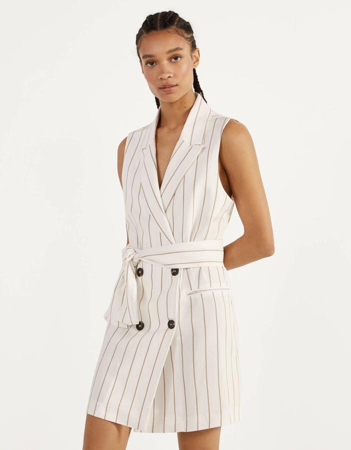 Si quieres decantarte por un ligero estampado, en Bershka propone este chaleco con cinturón y raya diplomática que también puedes llevar como vestido mini (25,99 euros).