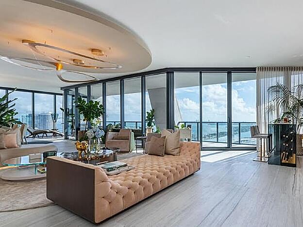 Una de las zonas más cálidas del apartamento es la del bar, con un gran sofá rosa.