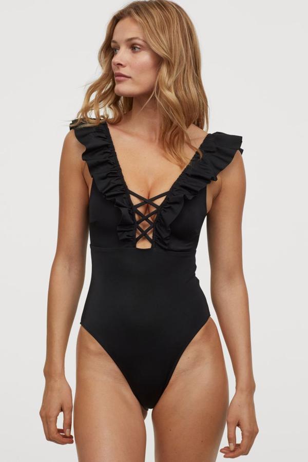 Uno de nuestros favoritos es este bañador negro con escote de pico profundo, lazada cruzada y ribete elástico delante y detrás con volante decorativo. Las copas tienen relleno para dar forma y cuesta 29,99 euros. Está disponible entre las tallas 34 y 48.