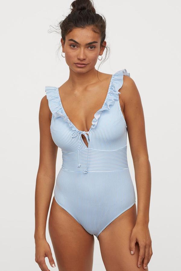 Con escote profundo de pico y lazada delantera, este bañador blanco con rayas azules es de H&M y cuesta 29,99 euros. Está disponible entre las tallas 34 y 48.