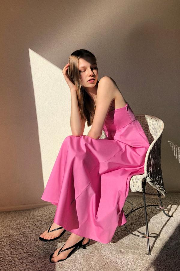 Vestido midi confeccionado en popelín de escote recto y tirantes finos cruzados en espalda. Lleva bolsillos laterales ocultos en costura y cierra en un lateral con cremallera (29,95 euros).