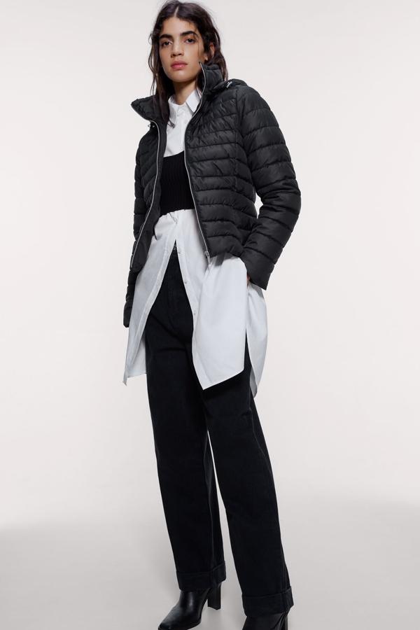 Zara nos propone esta cazadora acolchada con capucha. En color negro y entallada, tiene cierre frontal con cremallera y cuesta 29,95 euros. Está disponible en cinco colores más y la puedes encontrar desde la talla XS a la XXL.