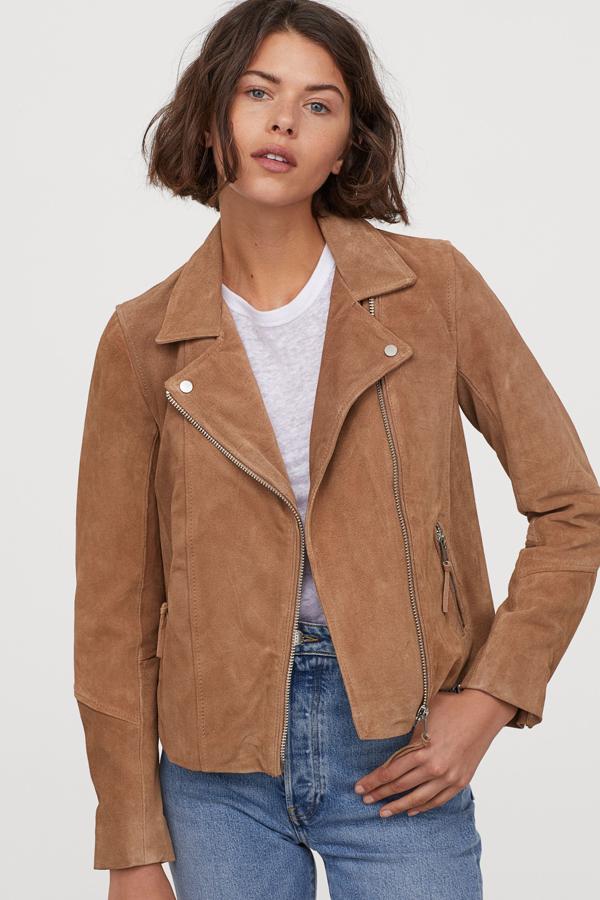H&M nos propone esta cazadora motera de ante suave con solapas, bolsillos delanteros y cremallera en los puños. Tiene un precio de 99 euros y está disponible en beige oscuro y negro.