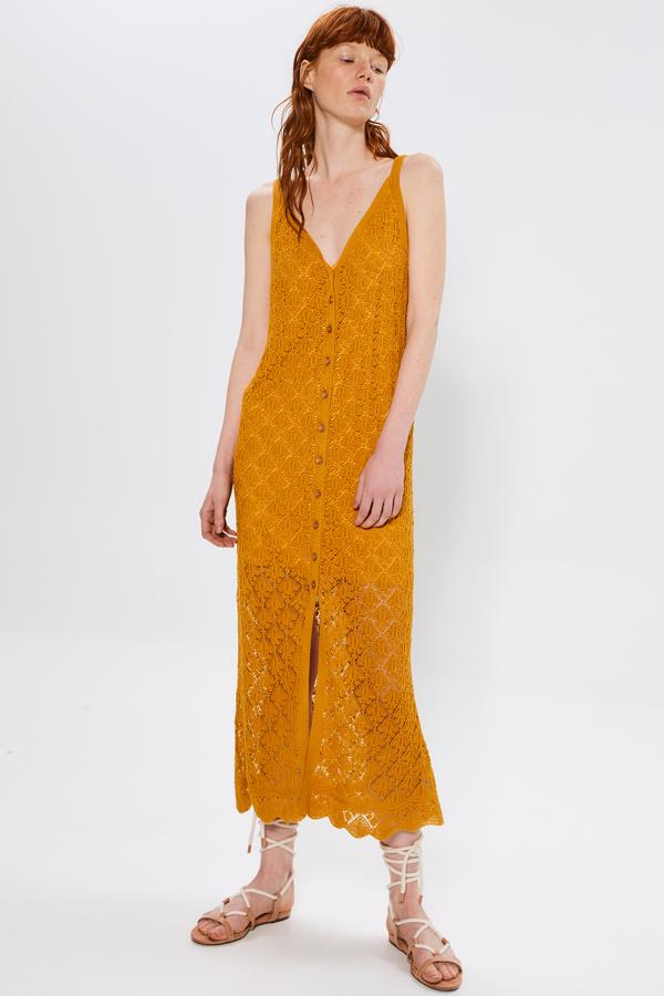 En color mostaza descubrimos en Sfera este vestido de punto crochet, con cuello de pico y detalle de botones que cuesta 39,99 euros. Está disponible en las tallas S, M y L.