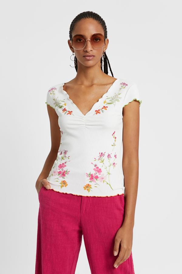 También de canalé, pero de manga corta y con un frunce a la altura del pecho para realzar el escote. Se adapta a la perfección al cuerpo, tiene los remates ondulados y un estampado de flores de lo más romántico.  Cuesta 39,95 euros.