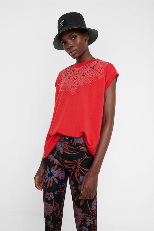 El color rojo intenso y los calados que tiene esta camiseta llaman la atención a primera vista. Si tú también has sentido el flechazo, ve a por ella. Ni te imaginas lo que favorece con una piel bronceada...  Cuesta 39,95 euros.