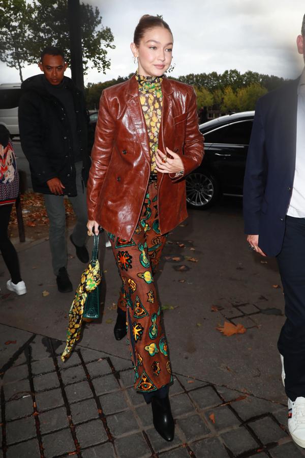 Con un look muy setentero, chaqueta de piel y un detalle muy top: un pañuelo como adorno del bolso.