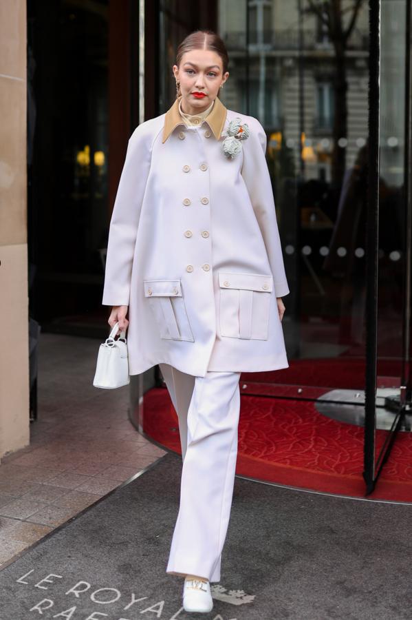 Con traje blanco de abrigo capa. Muy lady.