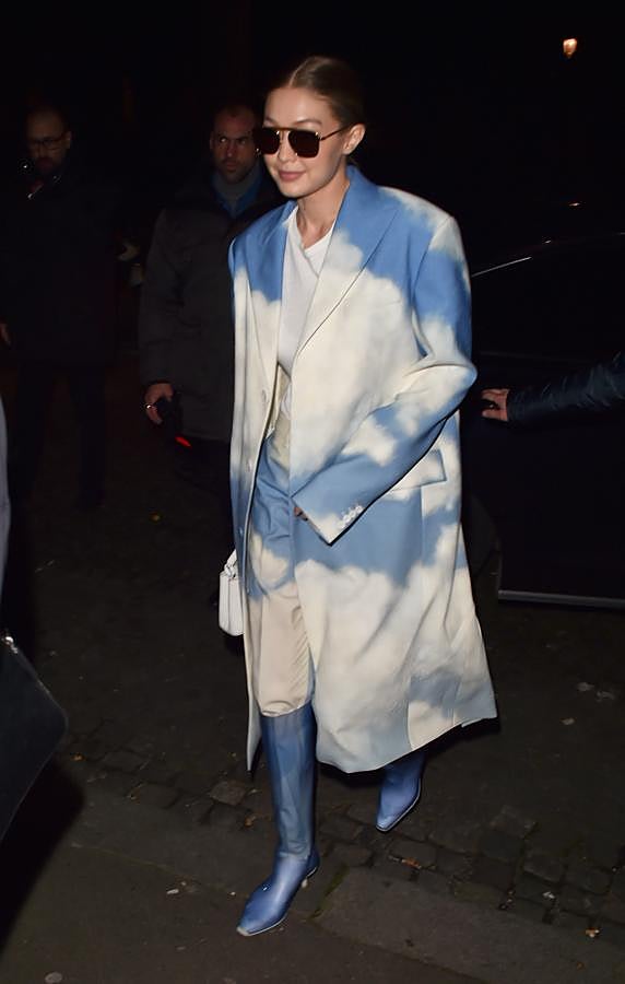 Con traje de pantalón y levita con un estampado de cielo. Lo combina con una sencilla camiseta blanca y unas botas azules de efecto metalizado.