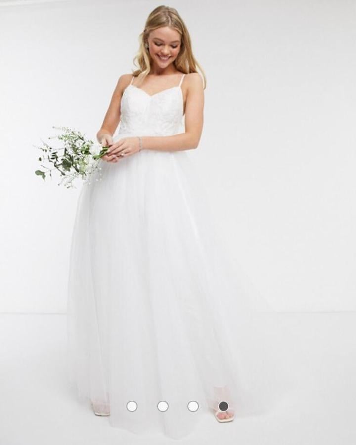 Vestido largo en tul blanco de Y.A.S Wedding con cuerpo de tirantes y bordado de flores (336,99 euros), disponible  aquí .