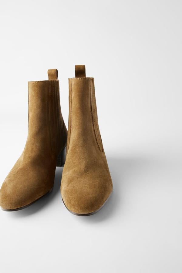 Confeccionadas en piel de color cuero, con corte de serraje y elásticos en los laterales, estos botines de tacón medio tipo cowboy han pasado de 39,95 euros a 25,99 euros. Están disponible entre los números 38 y 42.