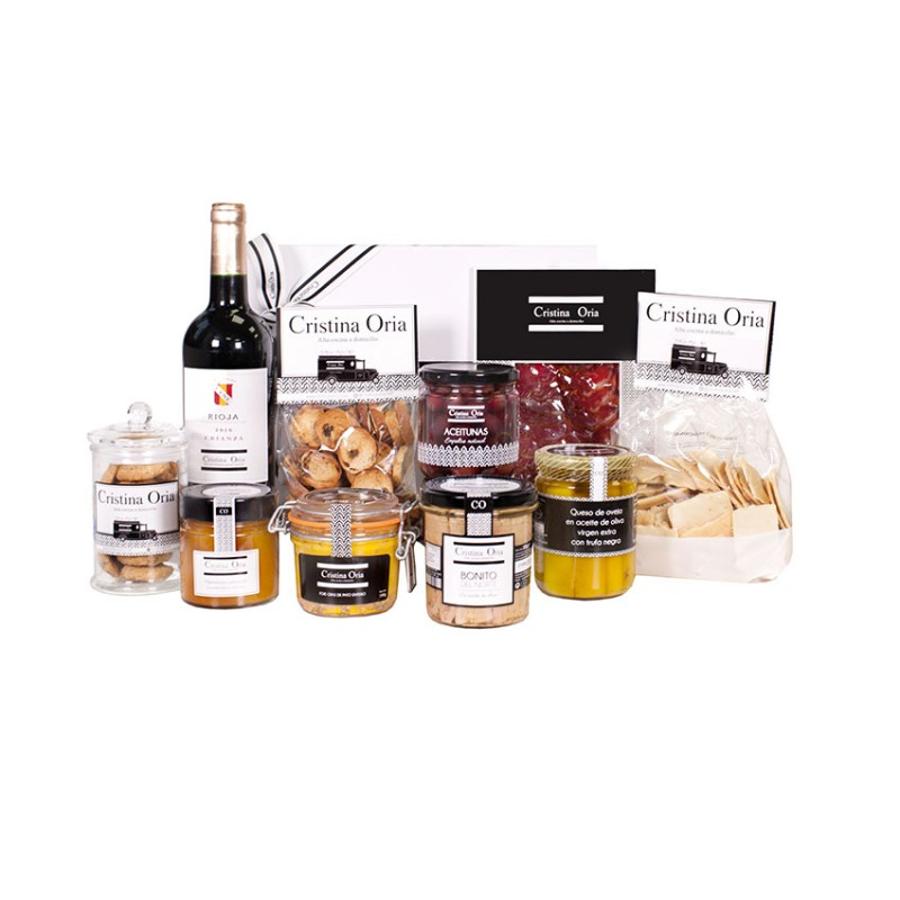 Una botella de vino, un buen queso, aceitunas... ¿Qué sería de nosotros sin un aperitivo? Ya que no se puede salir a celebrar el Día de la Madre a los bares, tendremos que hacerlo en casa. Este pack de Cristina Oria está disponible en su web y contiene: Foie cuit 180 gPan crostini de pasas 100 gQueso de oveja en aceite de trufa negraPan crackiss tradicional 250 gLomo iberico al vacio 80 gBonito del norte en aceite de oliva coAceitunas COVino Cune Rioja CrianzaMermelada artesanal CO 230 gCookies de avena y chocolate en caja de flores CO 110 g