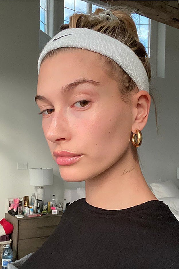 Hailey Bieber en casa, con el típico look con moño que llevamos todas.