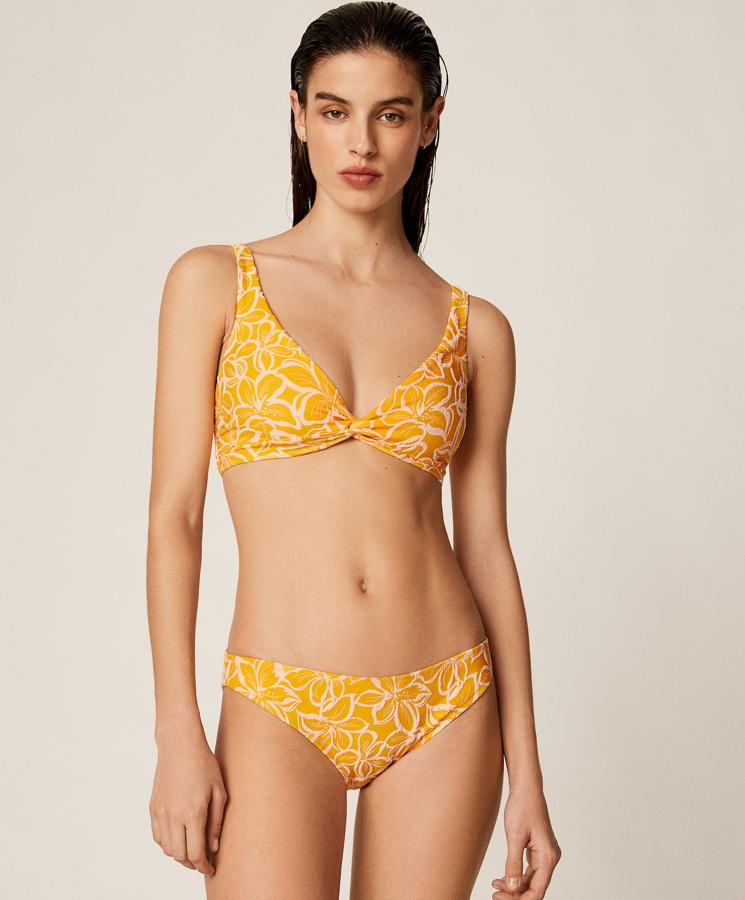 En color amarillo y con estampado de flores, este bikini de Oysho sienta de maravilla. Está formado por sujetador (19,99 euros) halter con tirantes ajustables mediante nudo trasero y braguita (12,99 euros) clásica a juego.