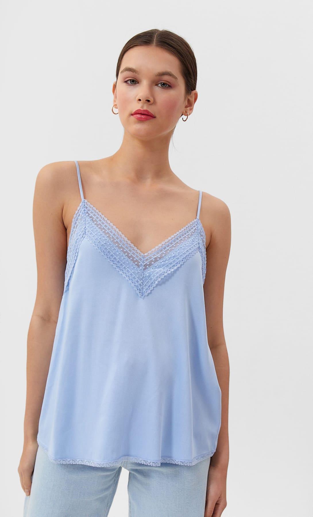 Top lencero con encaje y escote a pico en celeste de Stradivarius. (12,99 euros).