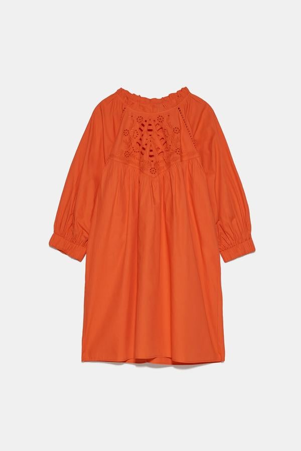 Vestido mini de popelín en color naranja con calados en la pechera, de Zara (29,95 euros).