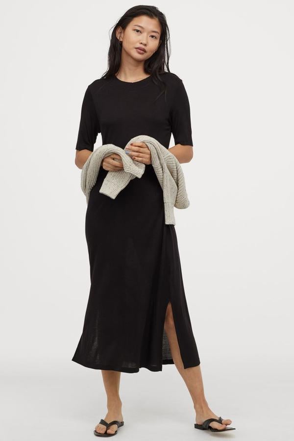 En H&M hemos encontrado este vestido midi en punto suave de viscosa con escote redondo ribeteado y aberturas laterales en color negro. Cuesta 14,99 euros y está disponible entre las tallas XXS y XL, aunque la L y la XL se están agotando.