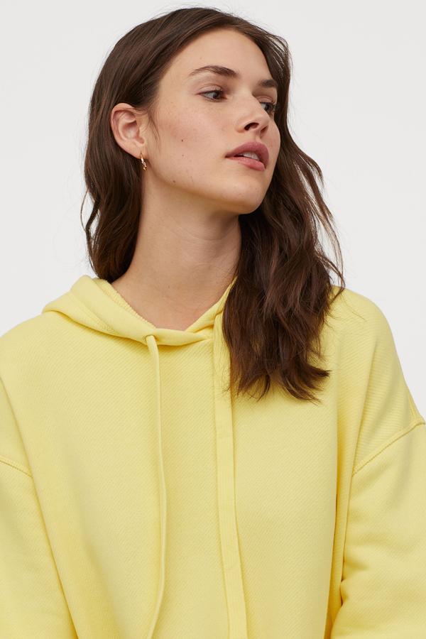 Sudadera amarilla con capucha, de H&M (29,99 euros).