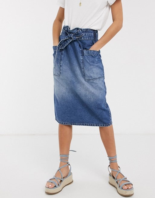 Falda midi en denim azul de JDY con cinturón anudado y bolsillos extragrandes. (25,99 euros). En Asos.