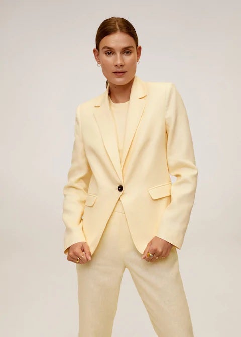 Mango apuesta por los tonos pastel en esta americana de lino en amarillo con hombreras y tejido de fibras sostenibles. (39,99 euros).