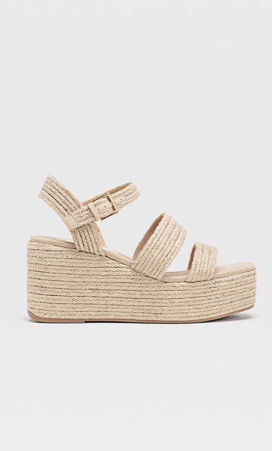 Sandalias de tiras trenzadas, con cuña de esparto en la suela, de Stradivarius (29,99 euros).