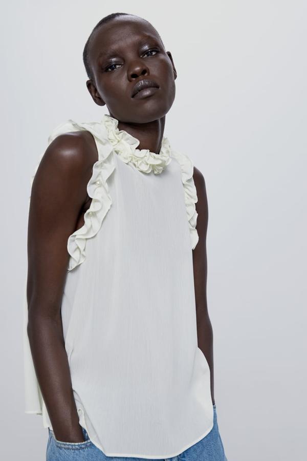 Top blanco con cuello redondo y volantes, de Zara (22,95 euros).