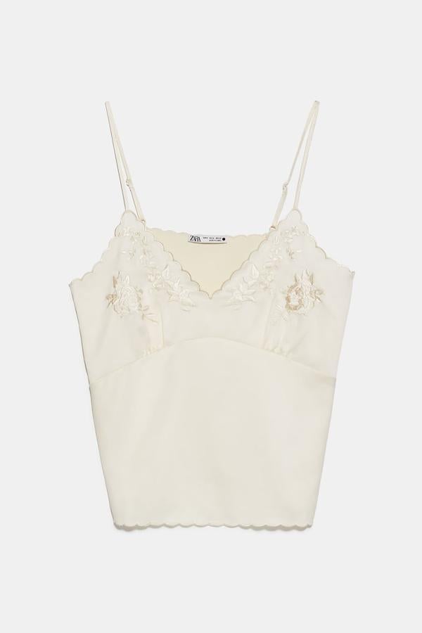 Con detalle de bordados, este top en blanco roto con tirantes finos ajustables es de Zara y tiene un precio de 15,95 euros.