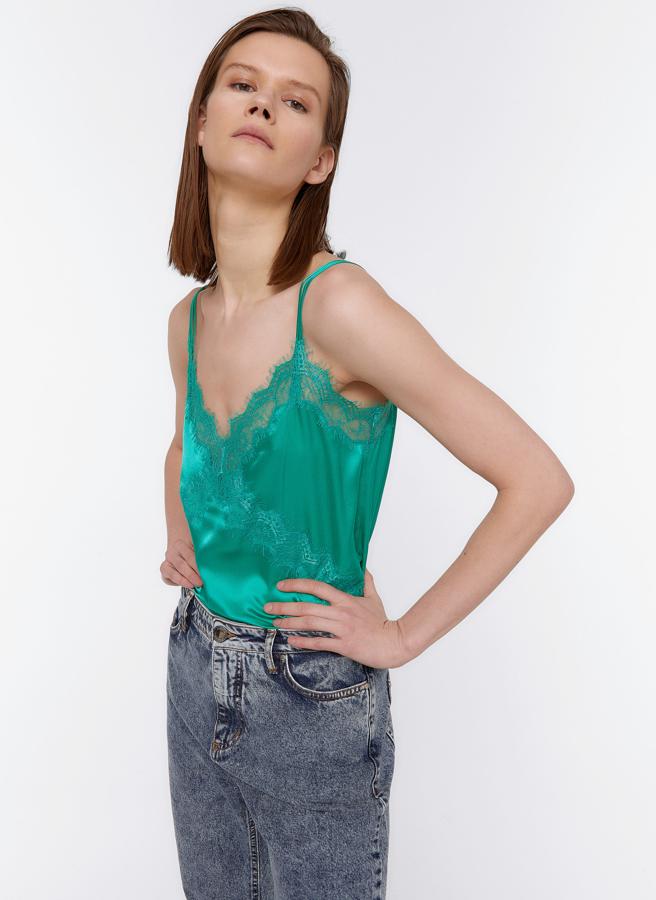 Confeccionado en seda satén, este top con detalle de puntilla de encaje en color verde (también está disponible en negro) es de Uterqüe y tiene un precio de 59 euros.