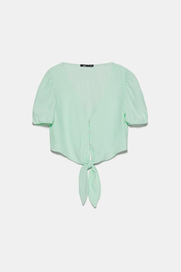 Este cuerpo corto de lunares en verde menta está volando. De manga corta abullonada y bajo con lazada, es de Zara y tiene un precio de 19,95 euros.
