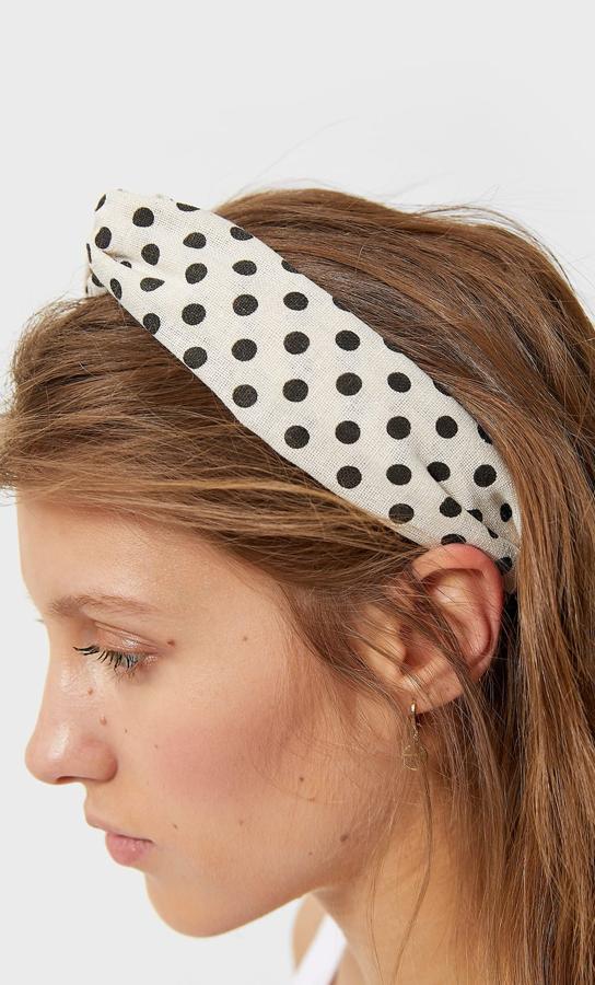 Stradivarius también nos propone lunares en accesorios como esta diadema en blanco roto con lunares negros. Tiene un precio de 5,99 euros.