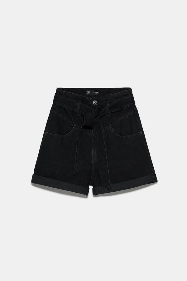 Con cinturón lazada y bajo acabado en vuelta, esta bermuda de tiro alto de Zara en color negro tiene un precio de 19,95 euros. También está disponible en azul claro.
