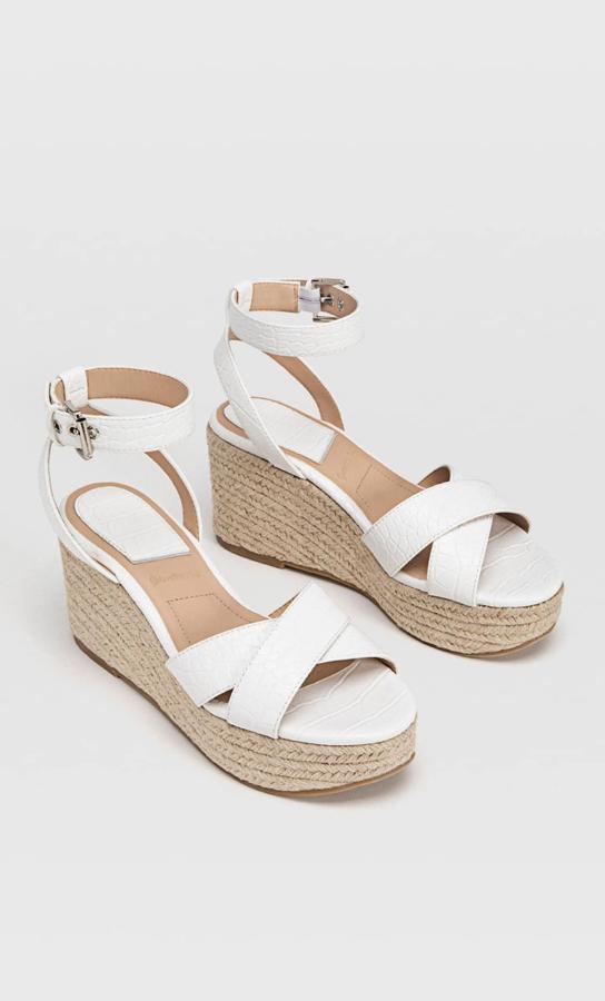 En color blanco, estas cuñas de yute con pulsera con hebilla al tobillo tienen ocho centímetros de altura y un precio de 19,99 euros.