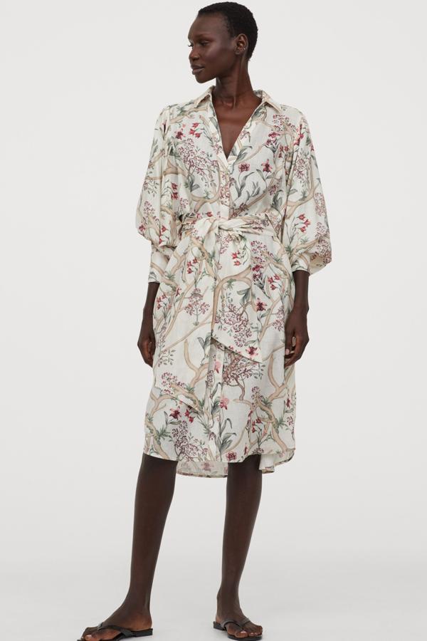 Este vestido camisero corto de lino en color blanco con estampado de orquídeas cuenta con cinturón para anudar extraíble. Tiene un precio de 39,99 euros.