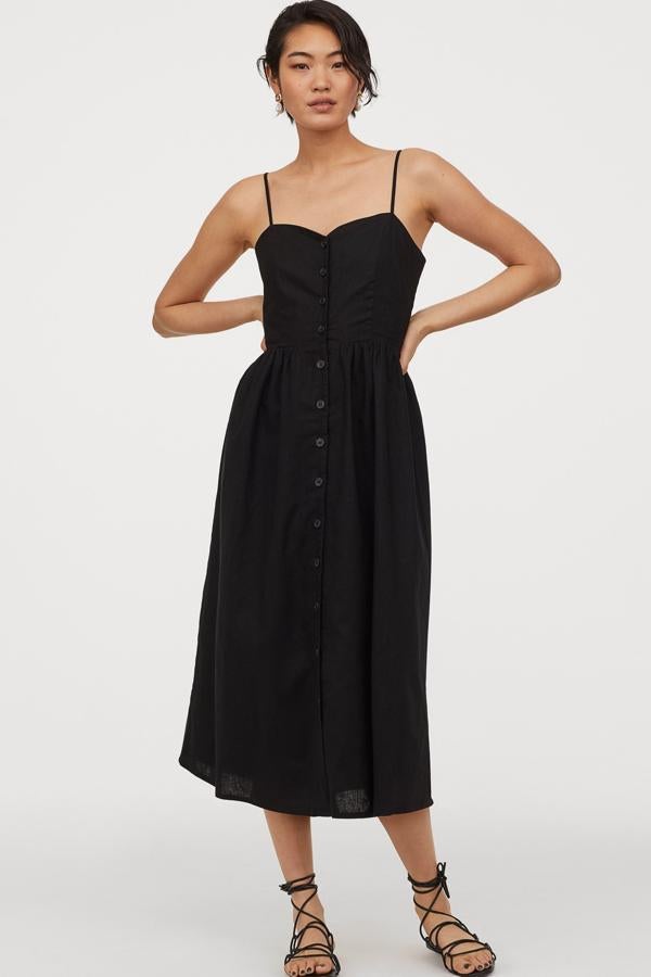 Este vestido midi negro con ligero escote de pico y tirantes finos ajustables está también disponible en blanco y con estampado en color azul. Con fruncido en la espalda y botones delanteros, tiene un precio de 29,99 euros.