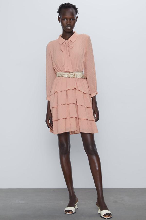 Este vestido de plumeti en color rosa claro con solapa con lazada está actualmente rebajado. Tiene un precio de 19,99 euros e incluye un cinturón con hebilla metálica.