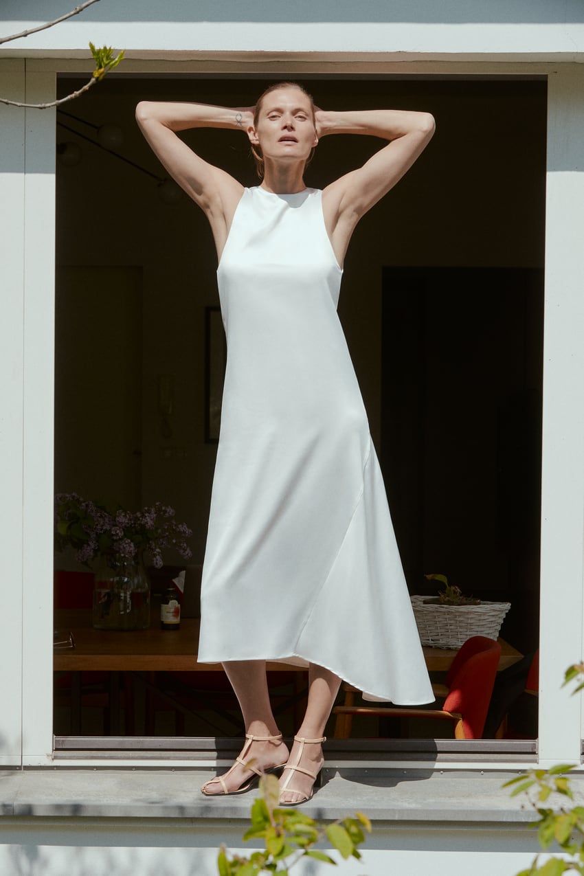 Vestido santinado asimétrico con manga sisa en tono blanco de Zara. (19,95 euros).