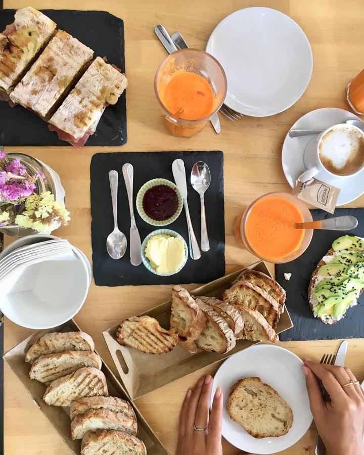 Desayunar fuera es uno de los placeres de la periodista. Seguro que dentro de poco vuelve a ser una realidad. En la imagen, un sueño de desayuno: pan blanco, mantequilla y mermelada, tostada de aguacate, zumo, café y lo que parece una deliciosa chapata ellena de jamón. ¡Qué aproveche!