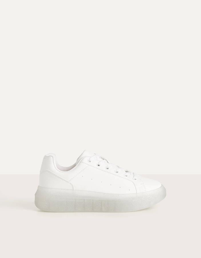 Sneakers blancas de Bershka con suela tranparente de purpurina (25,99 euros).