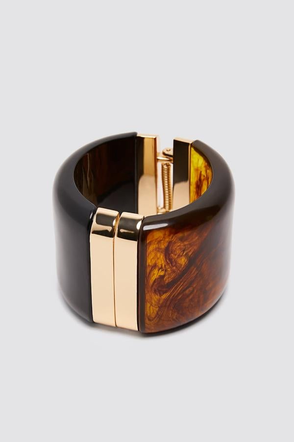 Brazalete de efecto carey con aplicaciones doradas, de Zara (19,95 euros).