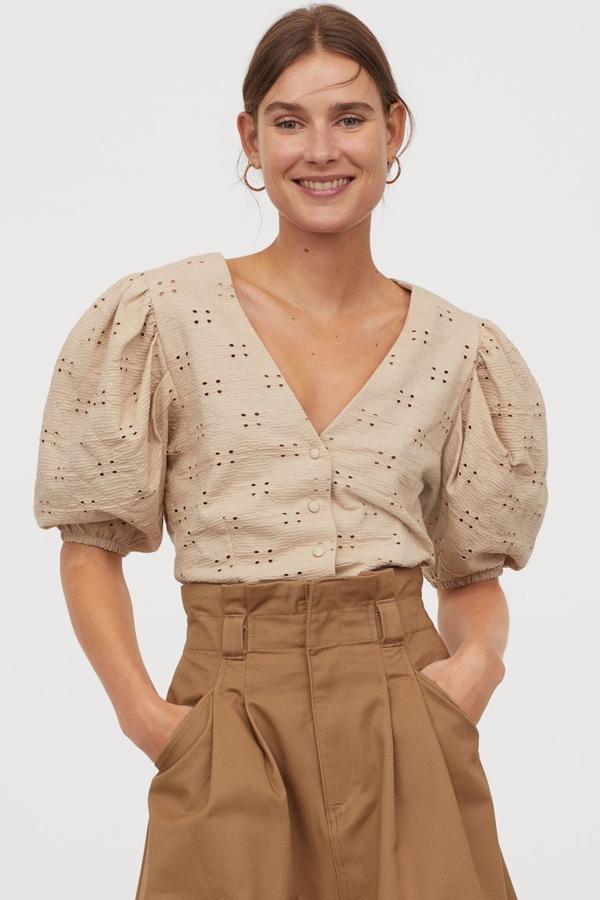 Este top entallado en punto elástico en color beige de H&M viene con un bonito bordado inglés y manga corta abullonada con remate elástico. Cuesta 14,99 euros y está disponible entre las tallas XS y XXL, aunque las tres primeras se están agotando.
