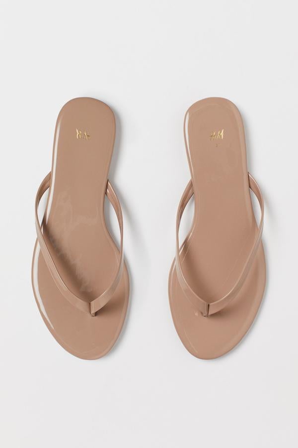 Disponibles en color beige o en negro, esta sandalia plana acharolada cuenta con tira al dedo y tiene un precio de 9,99 euros.