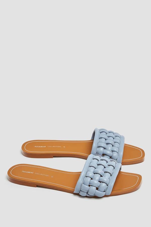Esta sandalia plana con tira de piel trenzada en color azul tiene un precio de 35,99 euros y asegura ser de lo más cómoda.