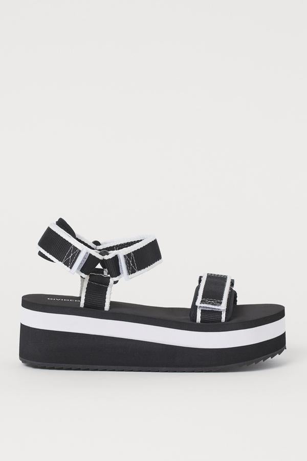 Estas sandalias con tiras de tela ligeramente acolchadas y cierre con tiras adherentes tienen un precio de 24,99 euros. En blanco y negro, la plataforma alcanza los 5,5 centímetros.