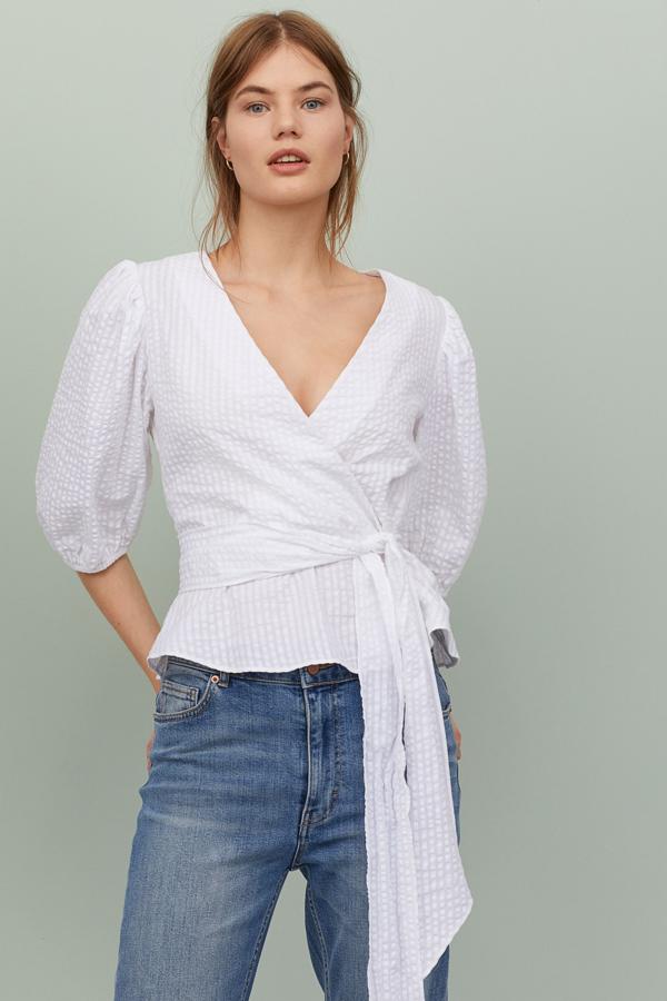 Blusa en tejido arrugado con mangas con volumen y lazada lateral, de H&M (19,99 euros).