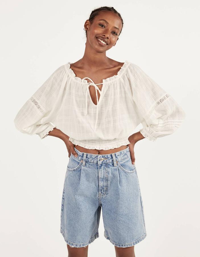 Blusa 'mesonera' con escote bardot y lazada,  de Bershka (19,99 euros).