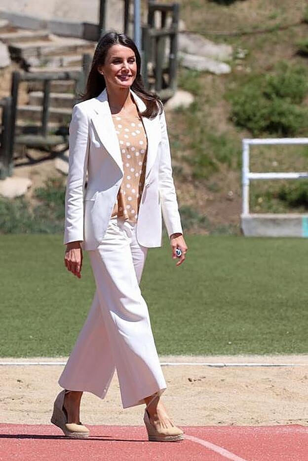 La reina Letizia ha apostado por un traje de chaqueta blanco con una blusa de lunares para su visita al Centro de Alto Rendimiento esta mañana en Madrid.