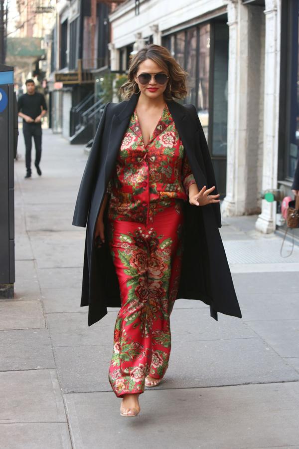 Chrissy Teigen demuestra que el clima no es un impedimento para lucir un pijama de seda incluso bajo un abrigo.
