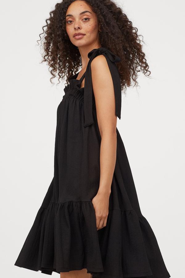 Este vestido de punto con volante ancho en el bajo, cuenta con tirantes con lazada arriba y escote con elástico. Disponible en color negro o en verde con estampado de leopardo, tiene un precio de 34,99 euros.
