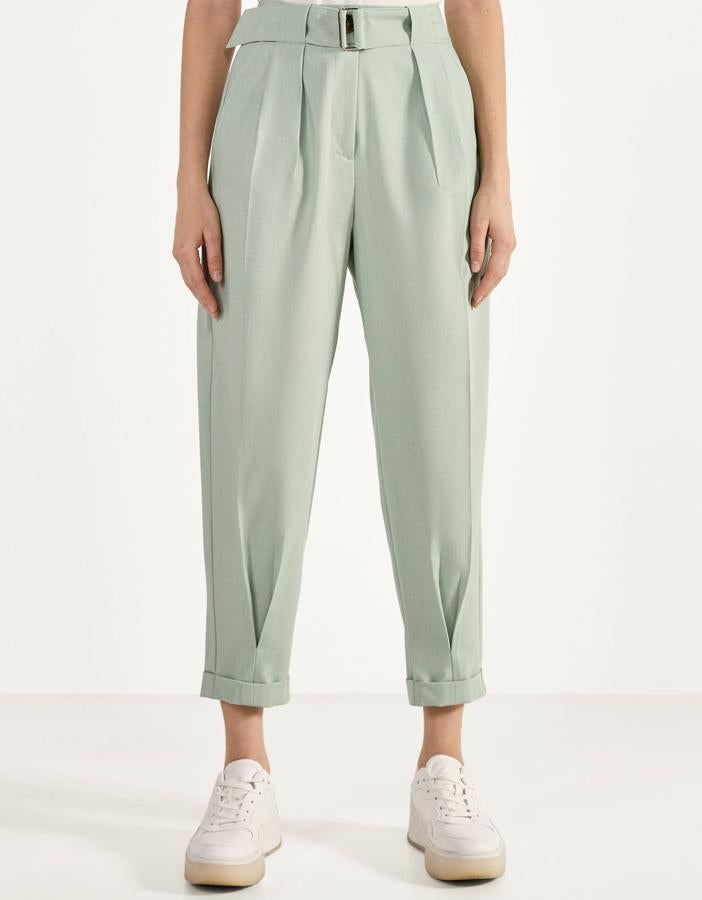 En color turquesa o camel, este pantalón slouchy con pinzas y cinturón cuenta con bolsillos frontales y bajo acabado en vuelta. Es de Bershka y tiene un precio de 22,99 euros.